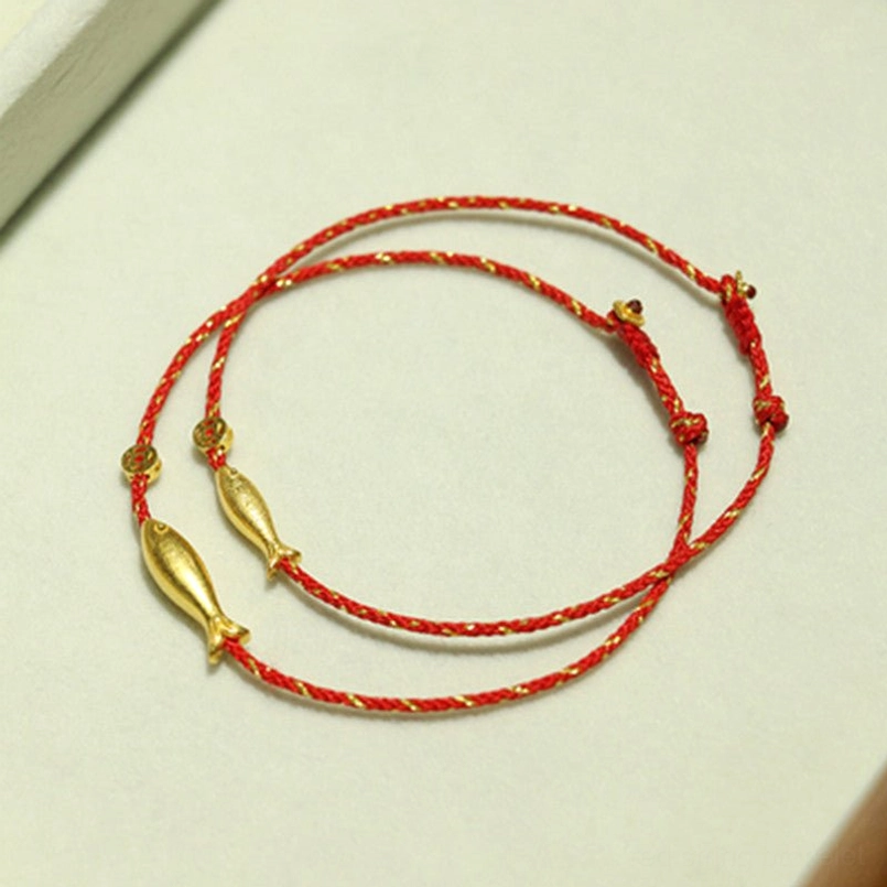 Double layer koi fish wealth bracelet with gold charm and woven red cord flat lay
