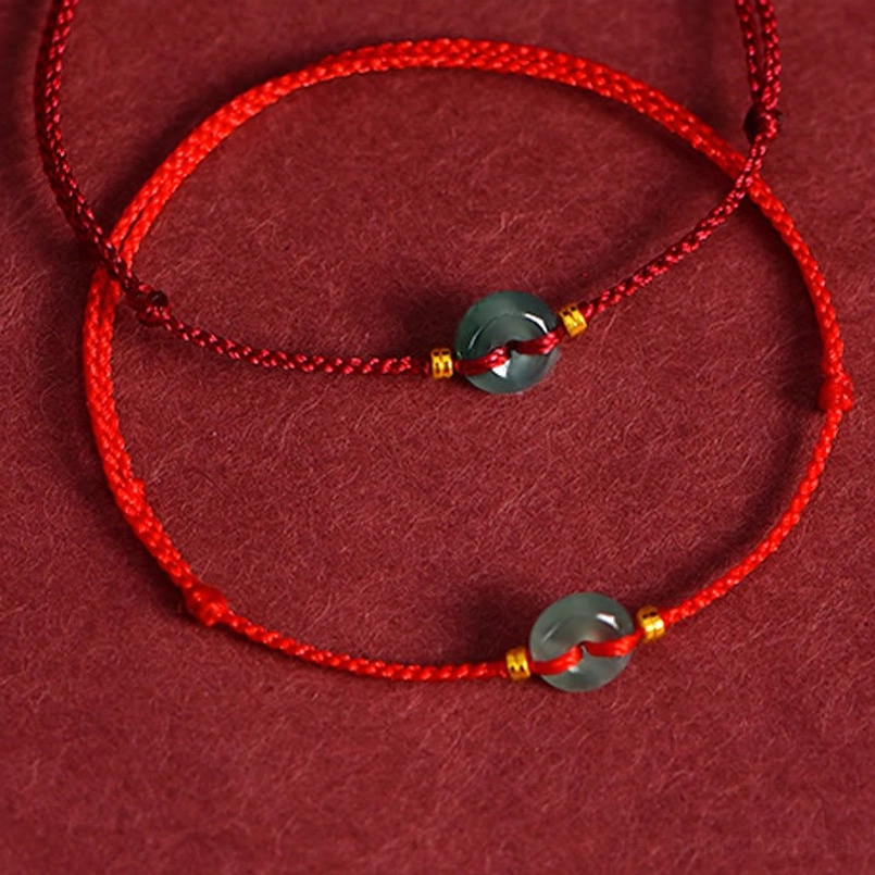 Double layer red string bracelets with jade peace buckles and gold copper coin charms - twisted cord flat lay