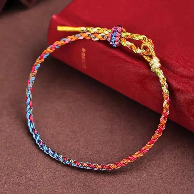 Colorful festival bracelet flat lay showing woven decorative knot and mixed color twine detail