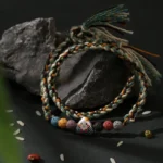 Dragon Boat Festival woven lucky bracelet flat lay on dark stone backdrop