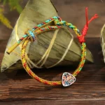 Multicolored Dragon Boat Festival Fu character bracelet with zongzi charm on wooden table