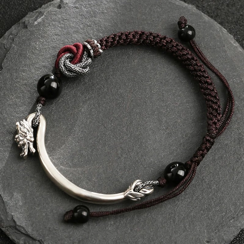 Overhead view of adjustable dragon bracelet showing braided cord and sliding bead closure mechanism