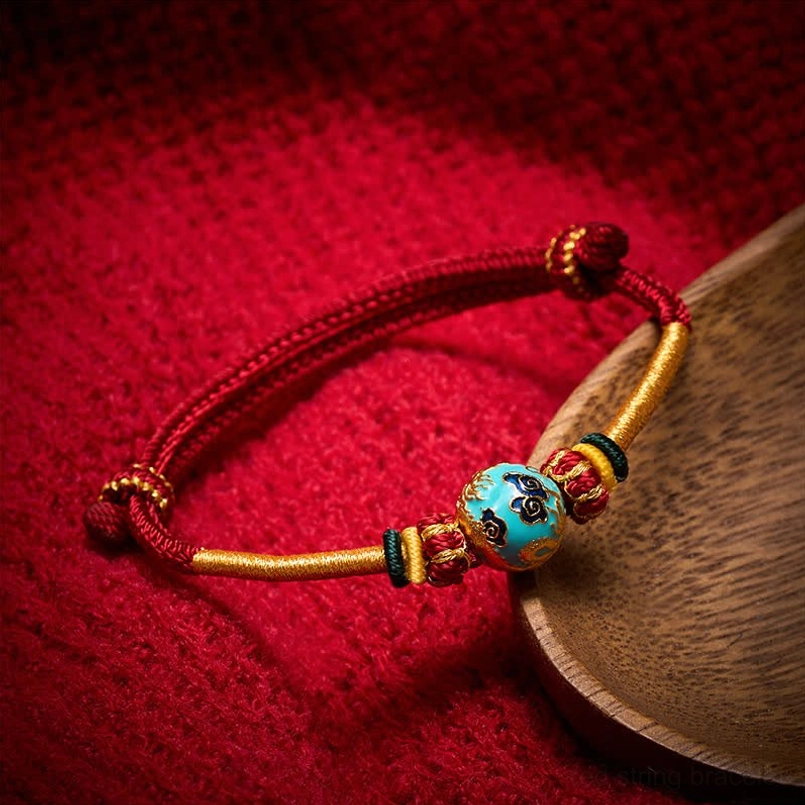 Blue-green jade carved bead on red string braided bracelet with coordinated cord accents