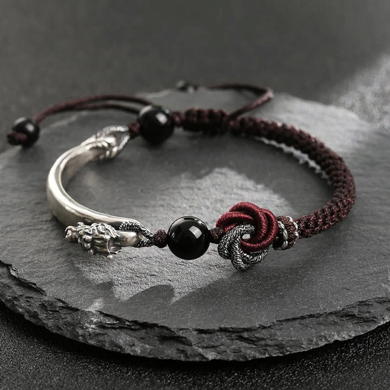 925 sterling silver dragon bracelet handcrafted with braided cord and mandala knot detail on dark slate background