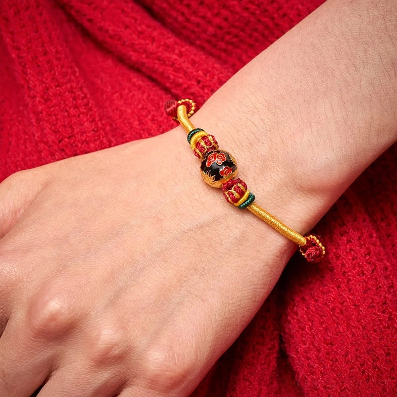 Dragon bead red string bracelet worn on wrist showing fit