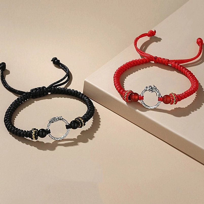 Dragon phoenix couple bracelets on angled platform - red and black cord styling