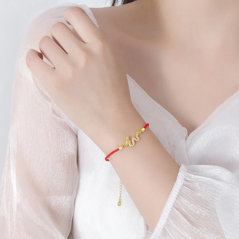 Dragon Red String Bracelet worn on wrist with gold dragon accent