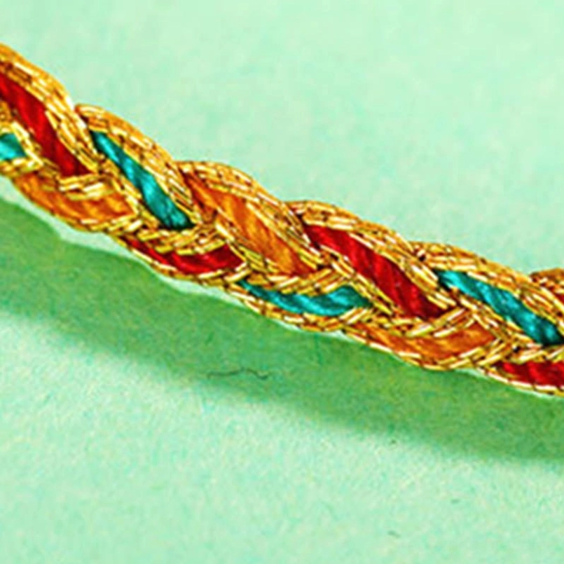 Slim multicolor braided dragon scale bracelet on gray mountain pattern background with adjustable knot