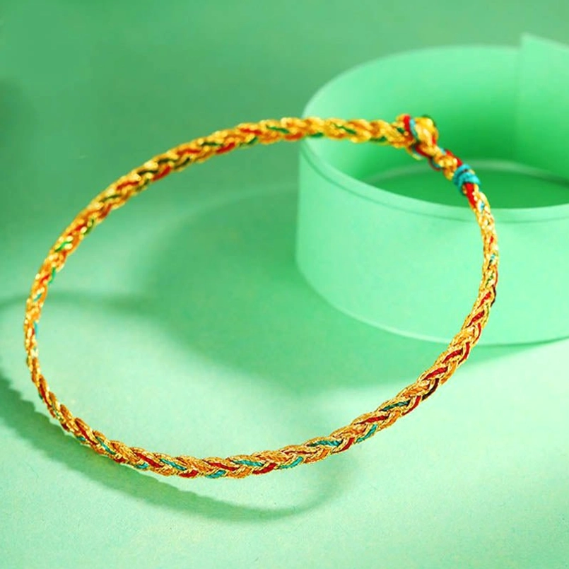 Handmade dragon scale bracelet on green background showing decorative end knot and colorful braided design
