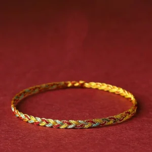 Handmade multicolor dragon scale braid string bracelet with gold, red and blue twisted pattern on burgundy background