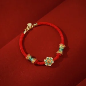 Dunhuang 925 sterling silver lotus drum red string bracelet flat lay on dark red fabric