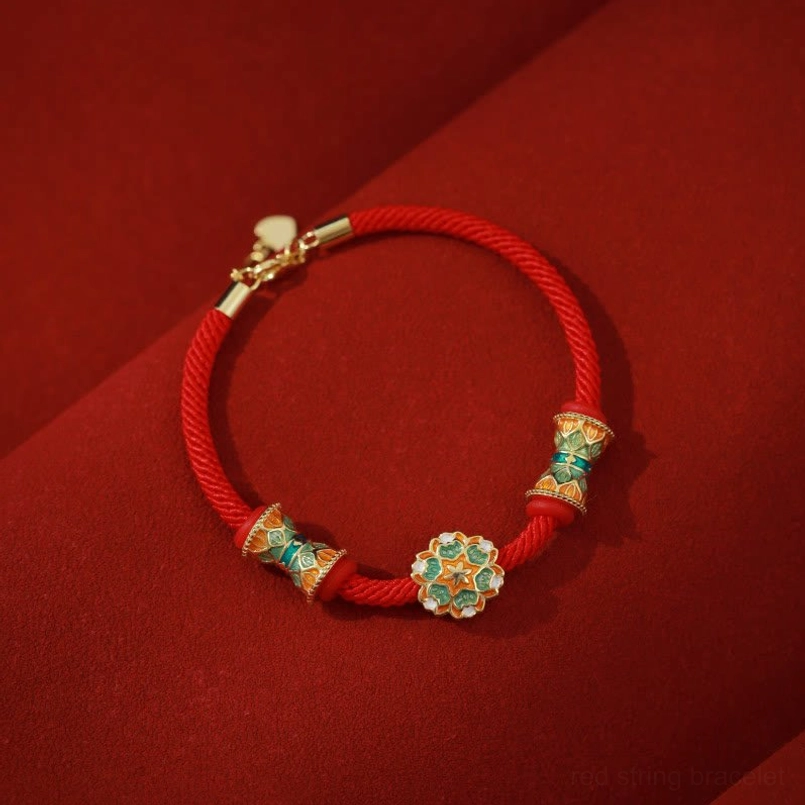 Dunhuang 925 sterling silver lotus drum red string bracelet flat lay on dark red fabric