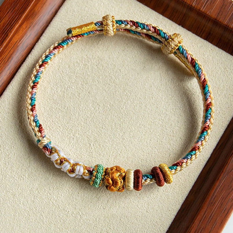 Complete view of handmade Dunhuang peach blossom bracelet with multiple decorative knots and braided structure