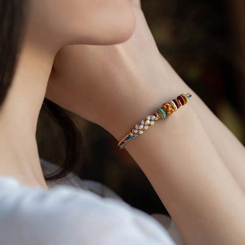 Handcrafted Dunhuang peach blossom red string bracelet with traditional braiding technique and flower decoration