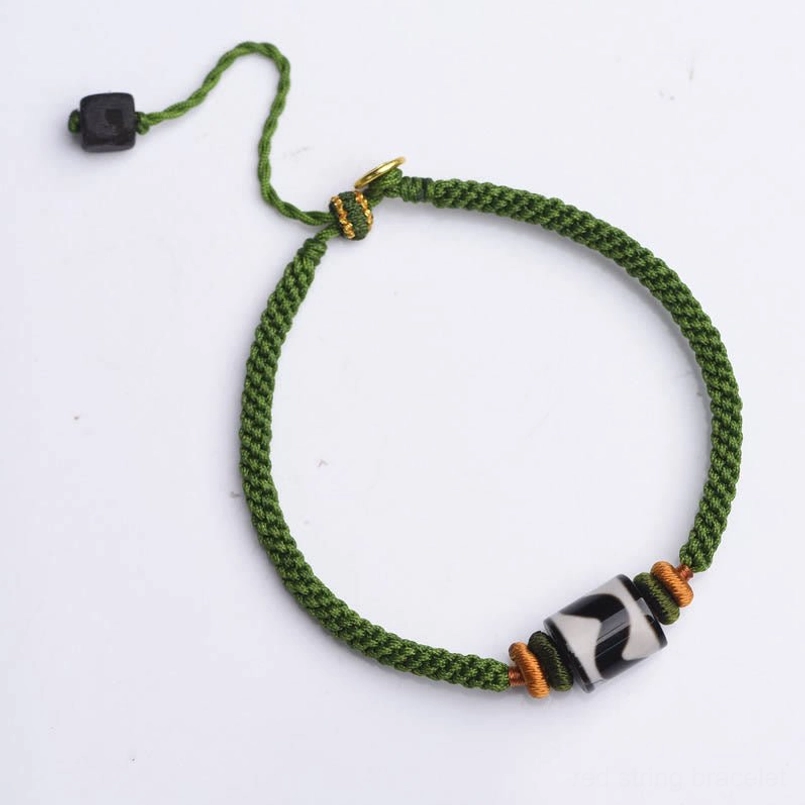 Tibetan Dzi bead green rope bracelet showcasing natural materials and traditional craftsmanship