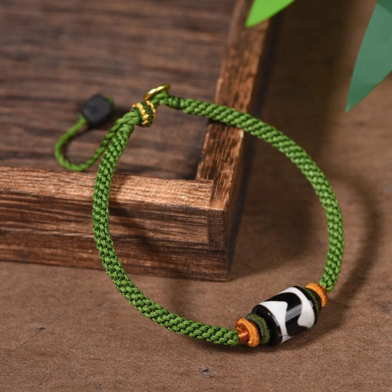 Tibetan Dzi bead green braided rope bracelet with black and white protective bead side view