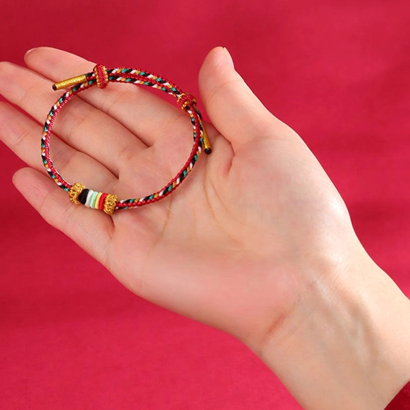 Yellow earth element feng shui wuxing bracelet with multicolor braids and spacer beads on red bagua pattern