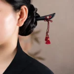 Ebony red string tassel hairpin worn in traditional hairstyle side view