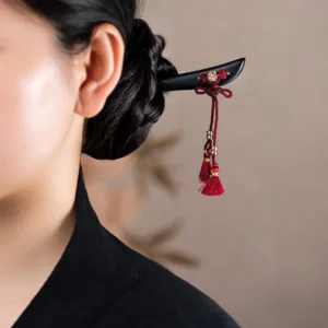 Ebony red string tassel hairpin worn in traditional hairstyle side view