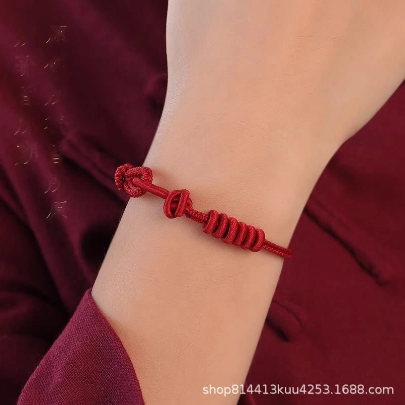 Adjustable knot detail of eight stranded red string bracelet on wrist