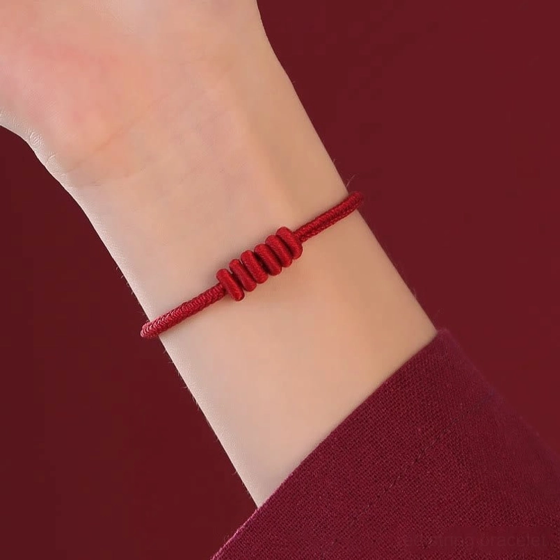 Eight stranded red string bracelet worn close up on real wrist