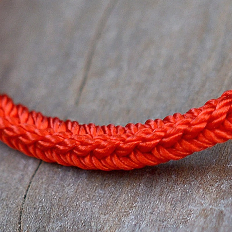 Detailed macro view of handmade red woven eight thread braided rope texture