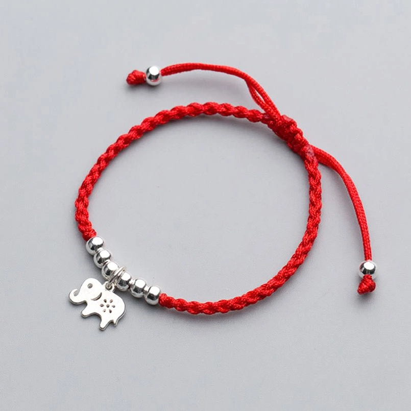 Adjustable red string bracelet with silver elephant charm and beads flat lay