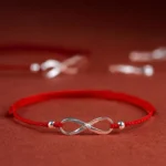925 sterling silver endless knot red string bracelet side view on wine red background