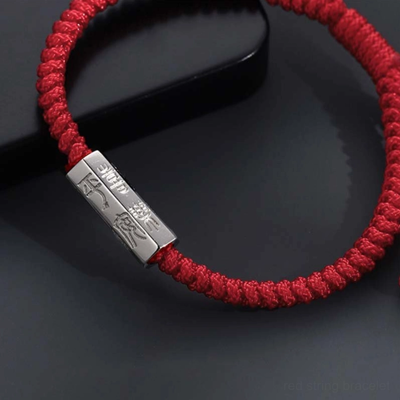 Close up of engraved 925 sterling silver charm on red string blessing bracelet