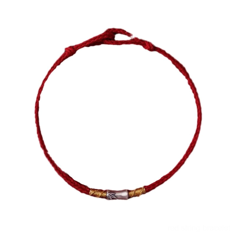 Lucky red string bracelet placed on soft fabric casual style shot