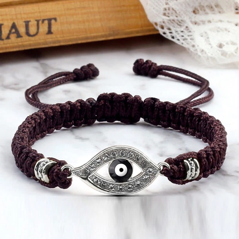 Close-up of evil eye charm detail with rhinestone and metal border construction