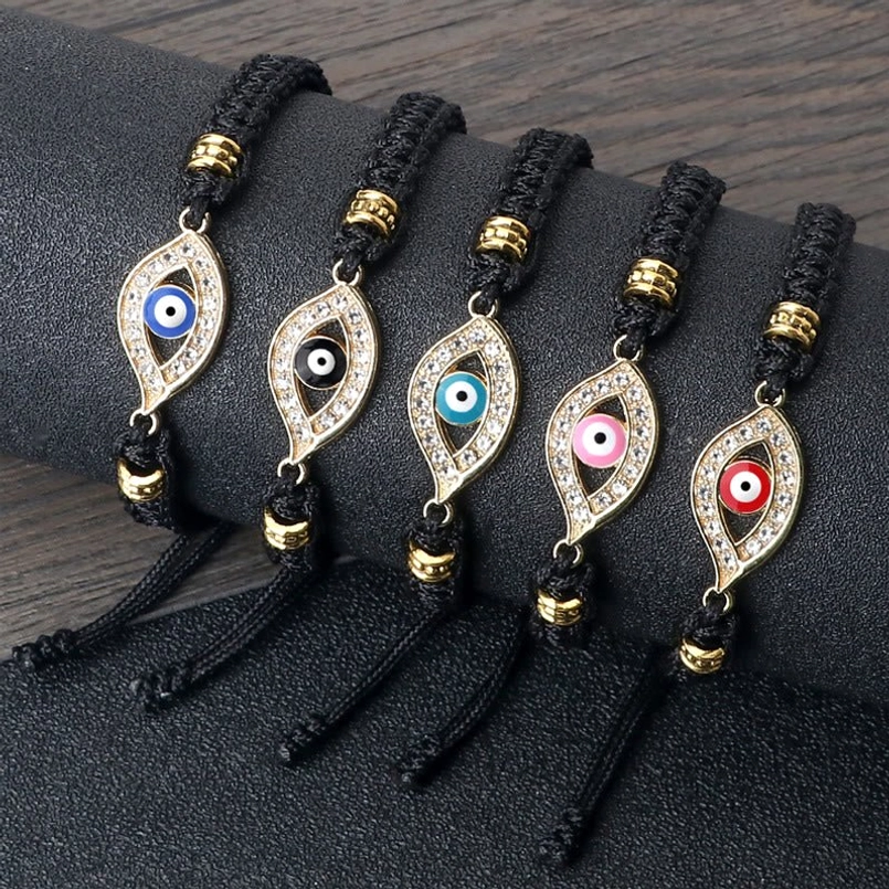 Evil eye string bracelets assortment on dark wood texture with various color options