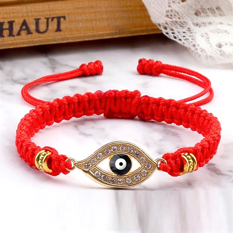 Gold border evil eye red string bracelet on marble surface with adjustable closure detail