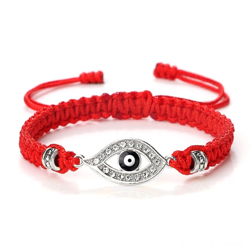 Silver border evil eye red string bracelet displayed on marble with rhinestone details