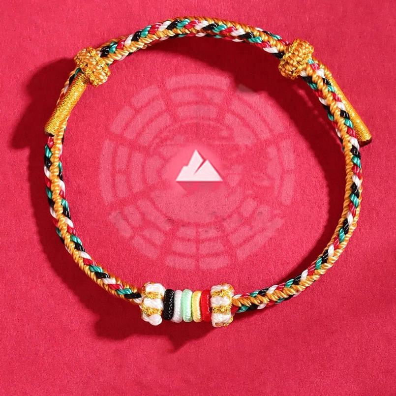 Mountain-themed woven lucky bracelet with multicolor braids, decorative knots and spacer beads on red bagua background
