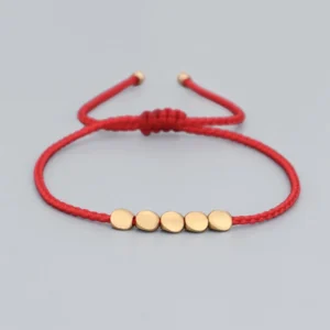 Feng Shui lucky red string bracelet with 5 flat copper beads on light gray background
