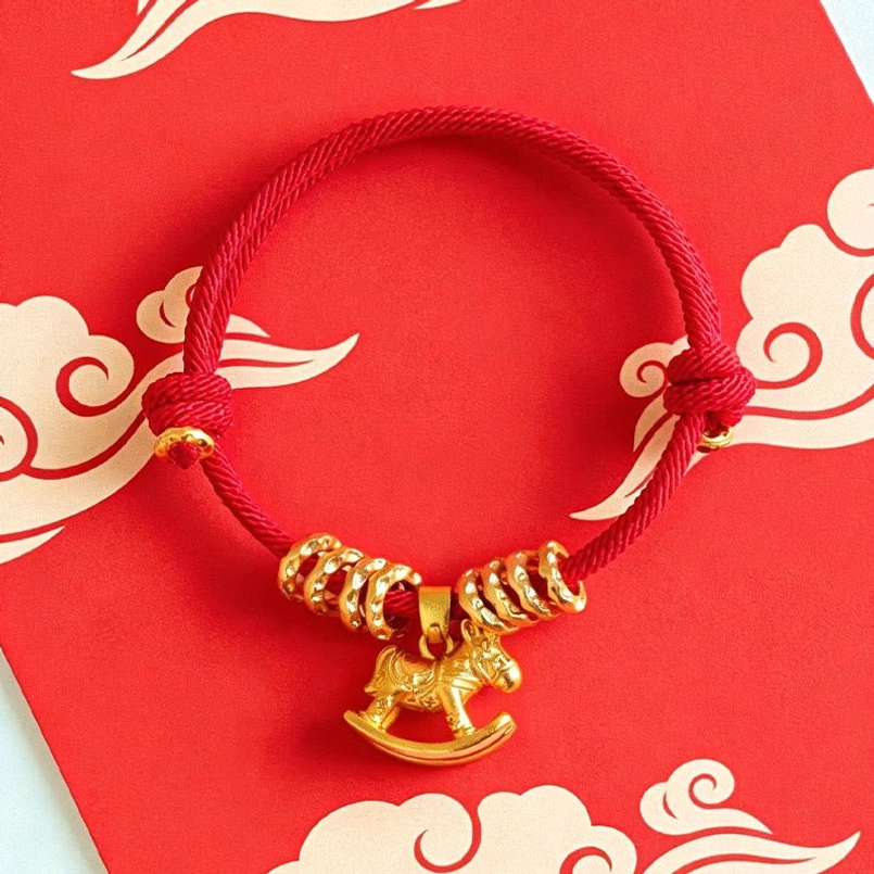 Festive red string horse bracelet on traditional Chinese red cloud background