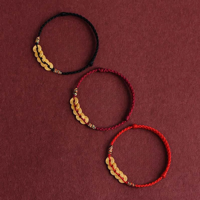 Five copper coins red string bracelet lifestyle worn on wrist showing prosperity protection meaning