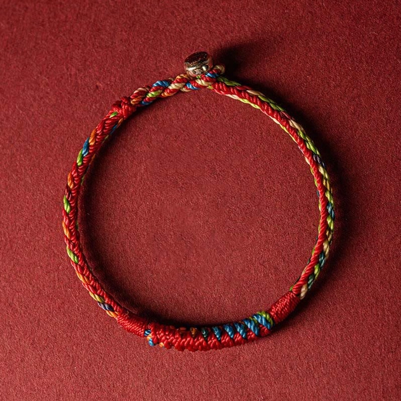 Handcrafted five color protection bracelet top down view showing neat braided threads and metal fastener