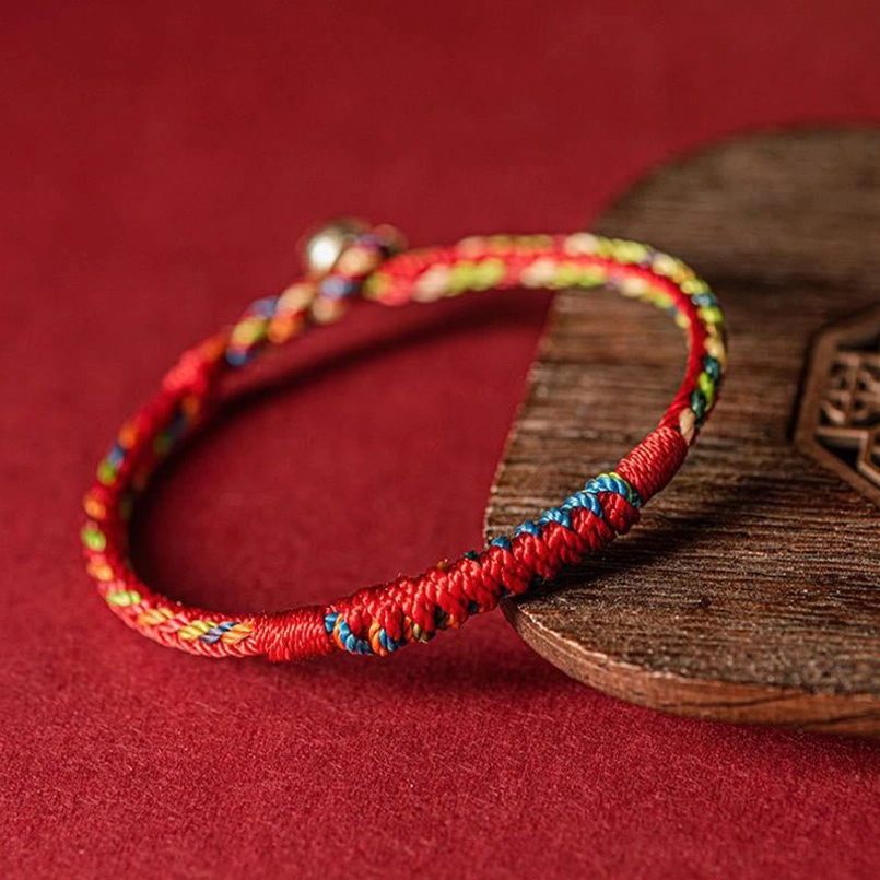 Close up view of five color braided protection bracelet knots showing vibrant mixed color threads
