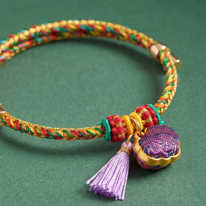 Close-up of handwoven five-color lucky bracelet with purple lock charm and spring metal clasp