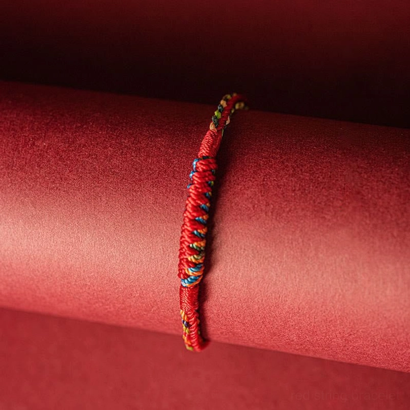 Five color woven protection bracelet side profile view showing colorful braided segments with red body