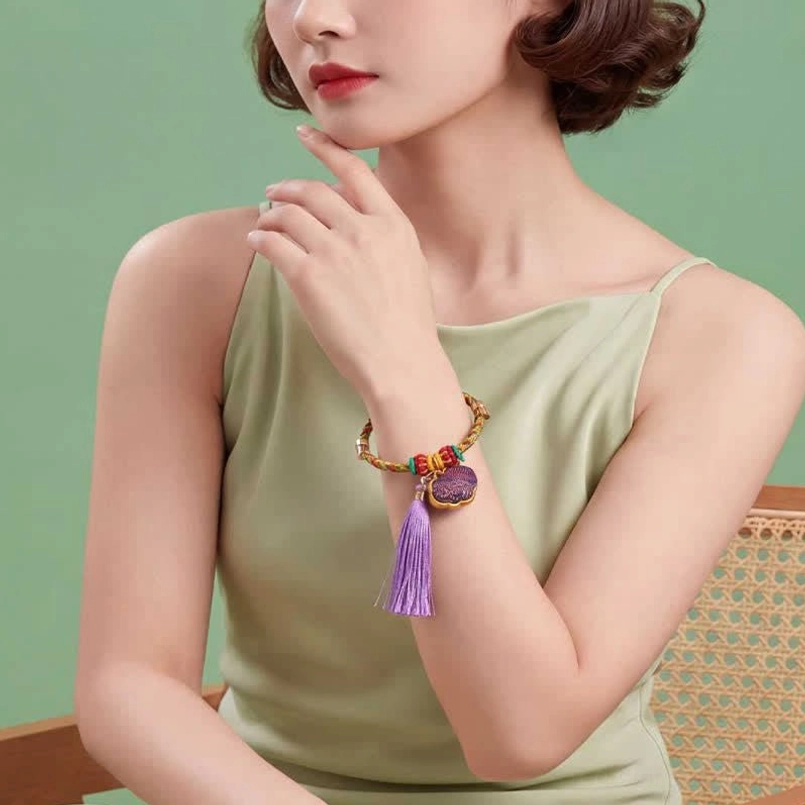 Five-color lucky bracelet with gourd pendant on ornate dark green embroidered velvet background
