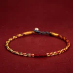 Handmade five color Tibetan luck bracelet with braided twisted rope and metal clasp - overhead flat lay view