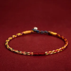 Handmade five color Tibetan luck bracelet with braided twisted rope and metal clasp - overhead flat lay view