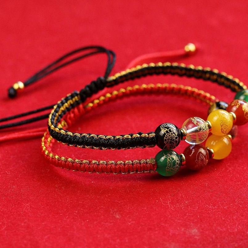 Multiple Five Directions braided bracelets stacked and overlapping with various cord styles and gemstones