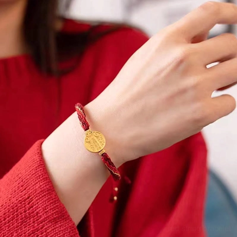 Five directions wealth red string bracelet worn on wrist, close-up side view showing comfortable fit and gold charm detail
