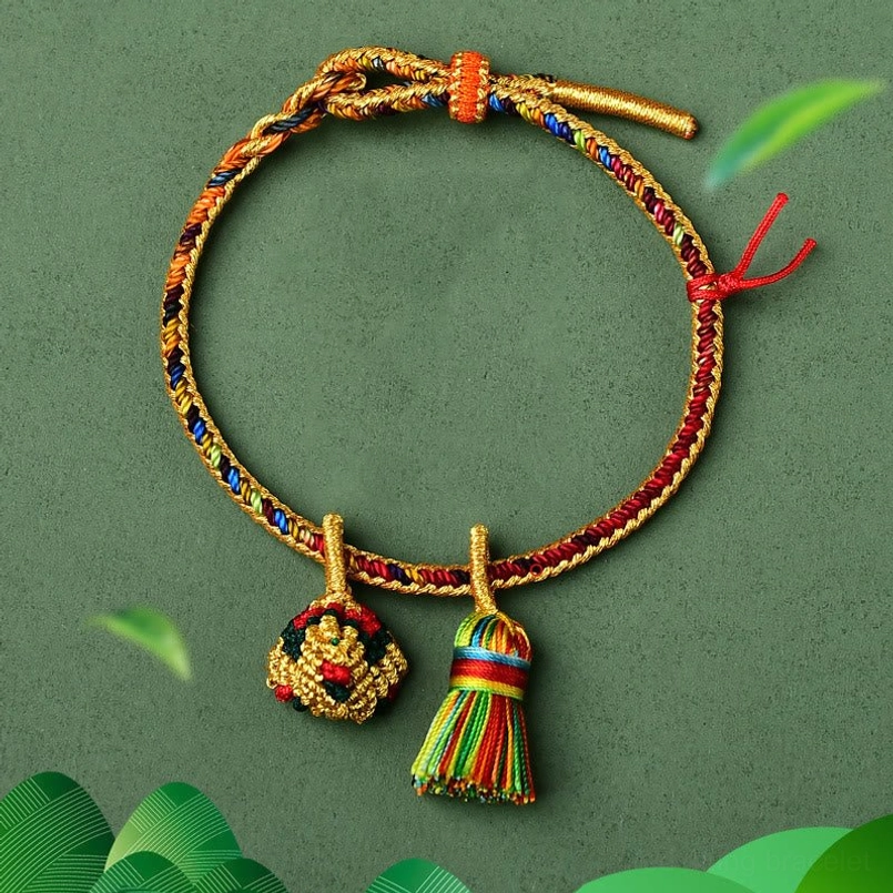 Five element colorful red string bracelet with golden ball charm flat lay dark background