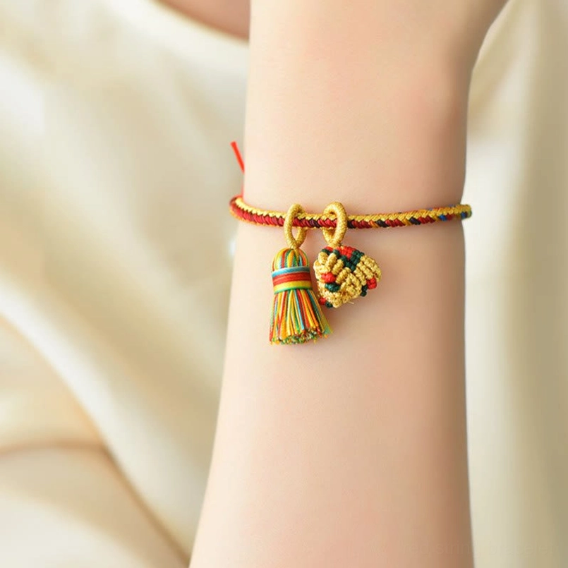 Colorful five element bracelet worn on wrist showing charm details light background