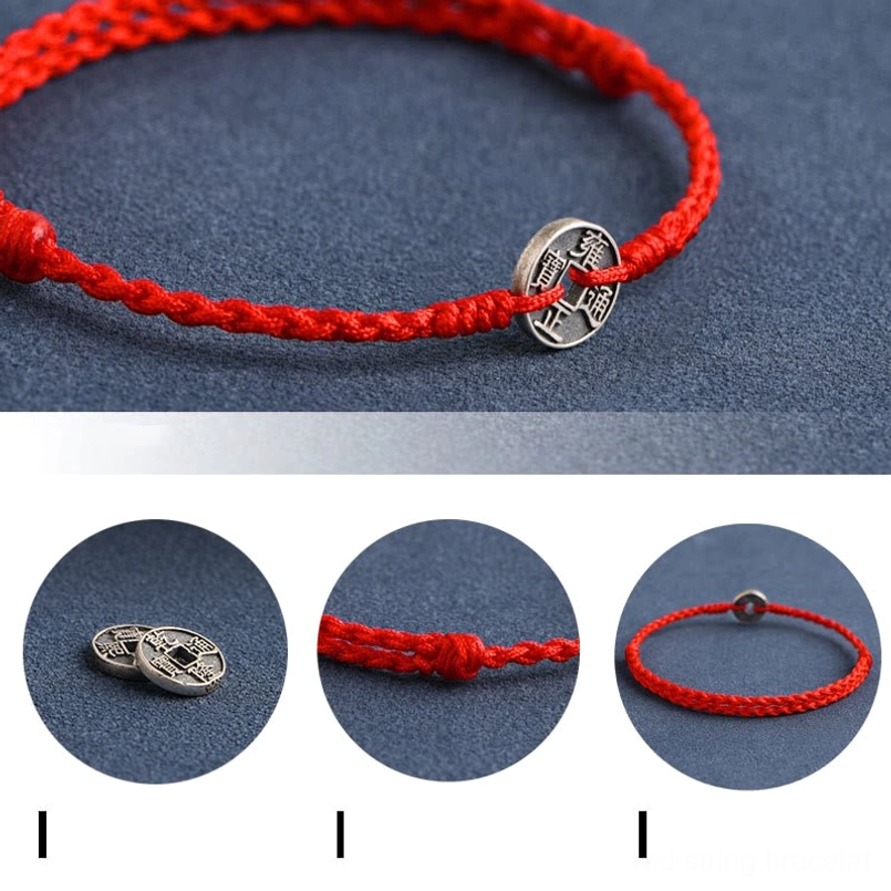High side view of braided red cord bracelet with antique silver five emperor coin pendant